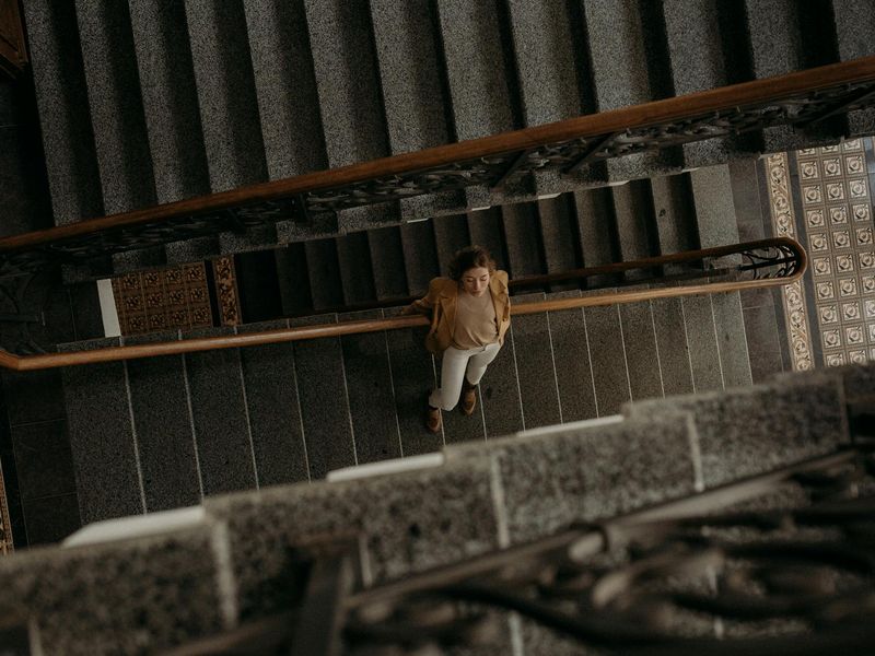 Person in a wide stance, captured mid-movement in a dark room.